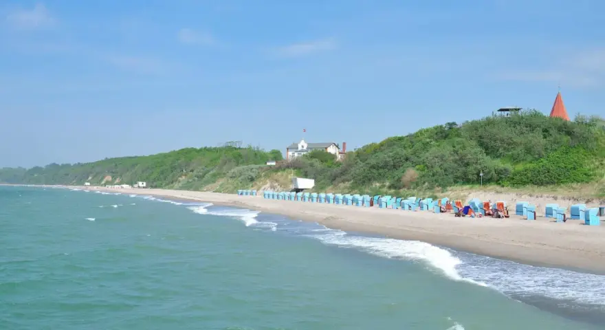Strand mit Strandkörben und grünen Hügeln. Hier finden Sie Rerik Geheimtipps für einen entspannten Urlaub an der Ostsee.
