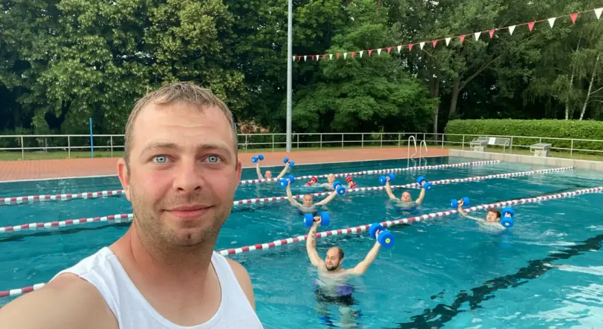 Wassergymnastik im Lindenbad Pasewalk: Eine Gruppe trainiert mit blauen Hanteln im Pool.