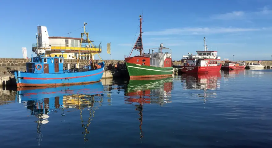 Boote im Hafen von Sassnitz Altstadt spiegeln sich im ruhigen Wasser.