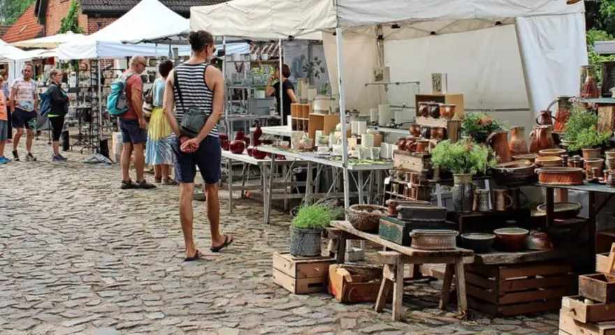 Bunter Trödel auf dem Flohmarkt Usedom. Keramik, Pflanzen und allerlei Schätze auf Kopfsteinpflaster.
