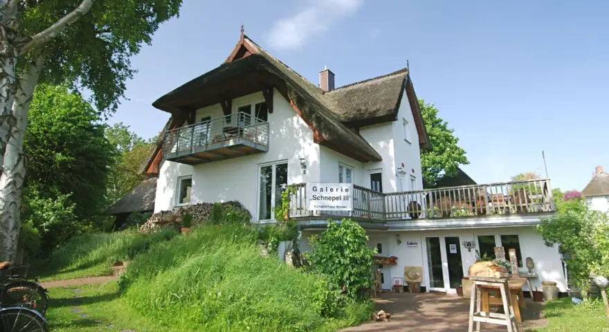 Galerie "Schnepel III" mit Kunsthandwerk und Veranstaltungen. Ein charmantes Haus mit Reetdach und Balkon.