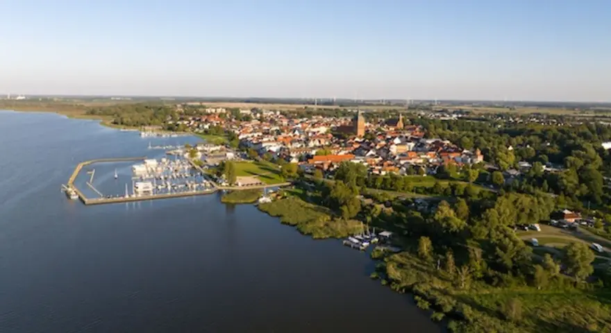 Luftaufnahme des Ribnitz-Damgarten Hafens mit vielen Segelbooten und der Stadt im Hintergrund.