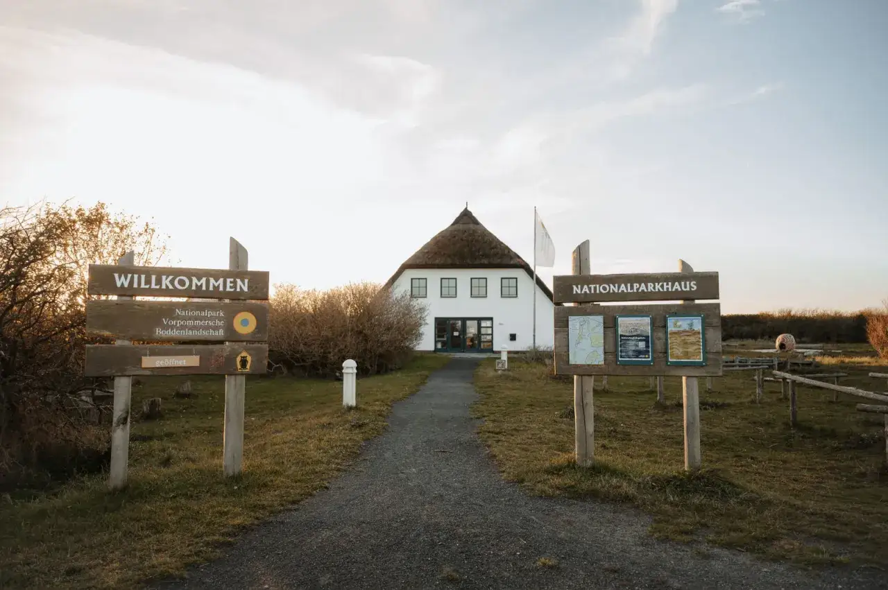 Willkommen am Nationalparkhaus in Hiddensee Vitte. Ein Weg f&uuml;hrt zum Haus mit Reetdach.