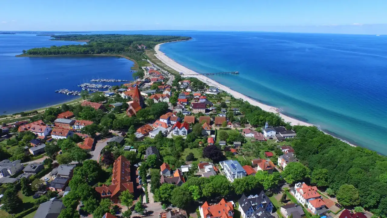 Luftaufnahme eines K&uuml;stenortes mit Yachthafen, Strand und Meer. Hier finden Sie Rerik Geheimtipps f&uuml;r Ihren Urlaub.