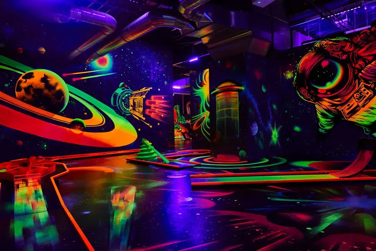 Neon-leuchtende Minigolfanlage in Koserow im Weltraum-Design mit Planeten, Raketen und Astronauten.