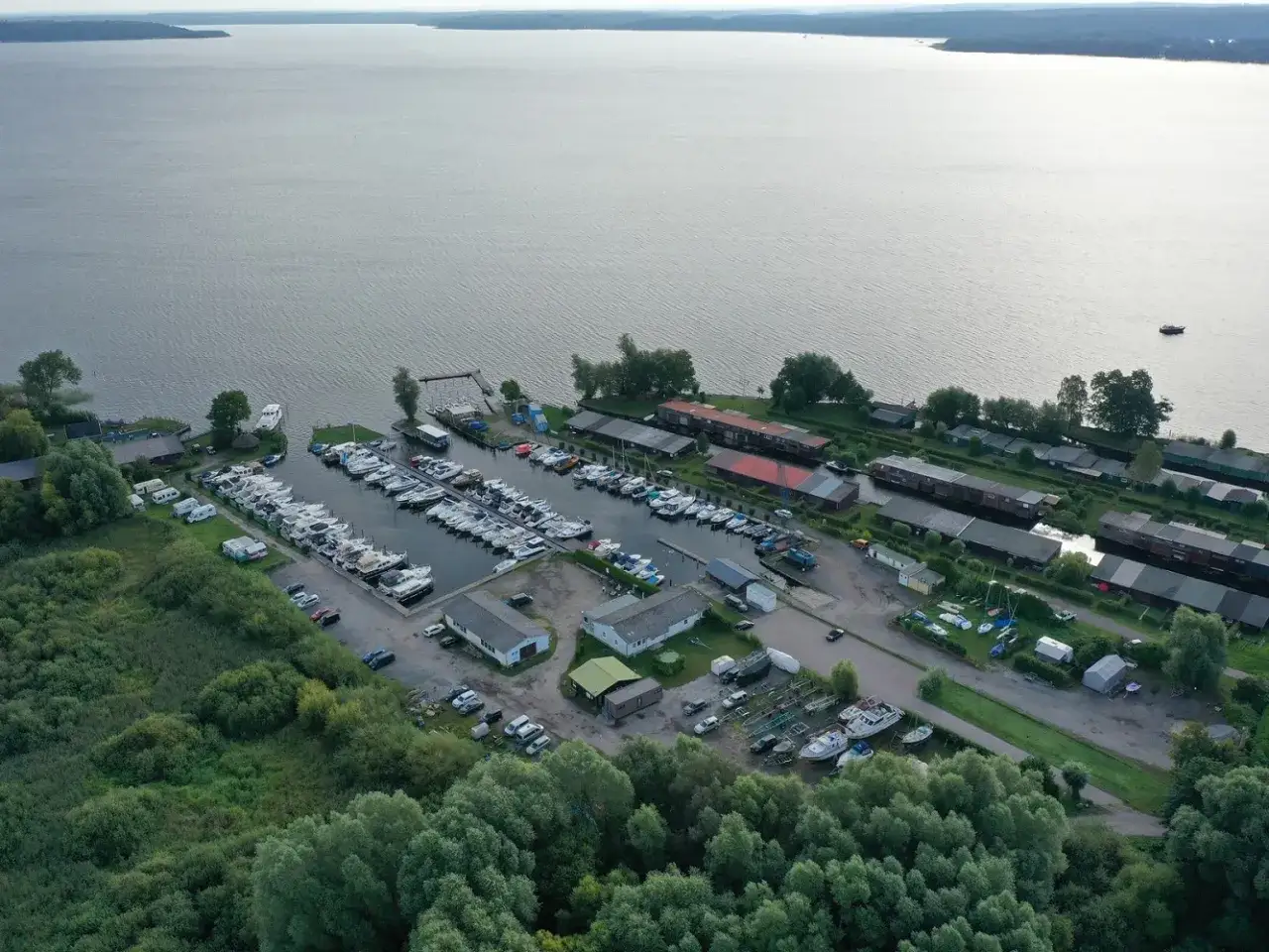 Luftaufnahme des Hafens Plau am See mit vielen Booten, Wohnmobilen und Gebäuden. Ein lebendiges Hafenfest Plau am See.