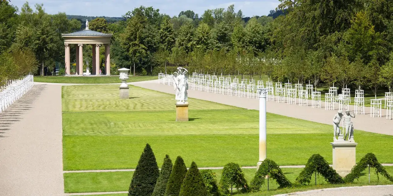 Der Schlossgarten Neustrelitz zeigt eine klassizistische Tempelarchitektur, Statuen und gepflegte Rasenflächen.