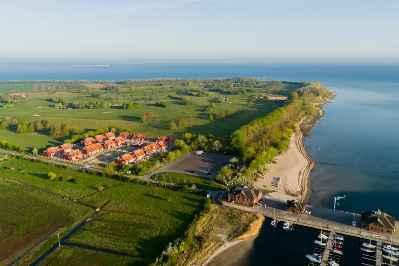Ferienhäuser am Meer, daneben ein Golfplatz und ein Yachthafen. Ein idyllischer Ort für Urlaub und Freizeit.