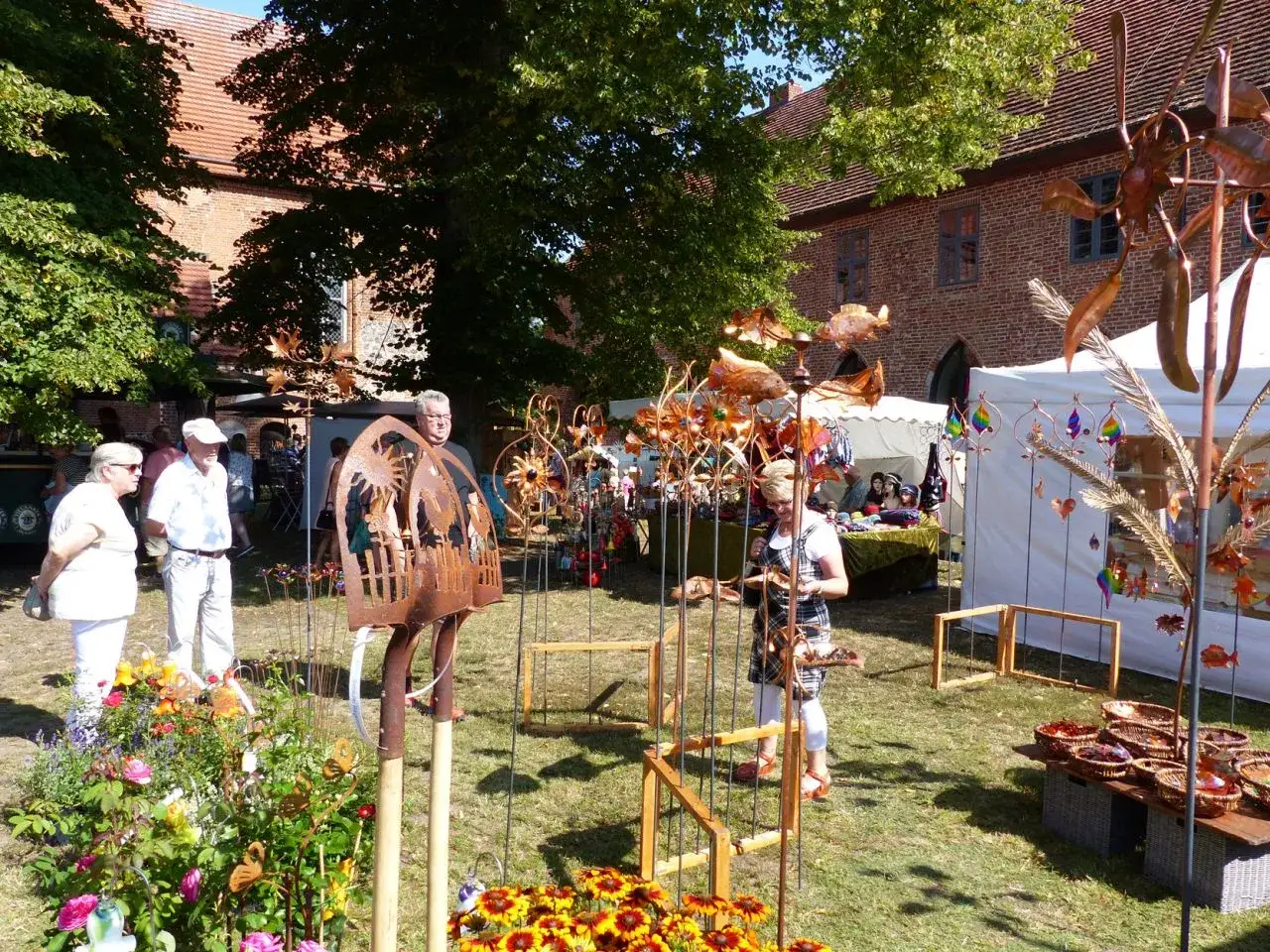 Besucher auf Zarrentin Veranstaltungen bestaunen kunstvolle Gartendekorationen aus Metall.