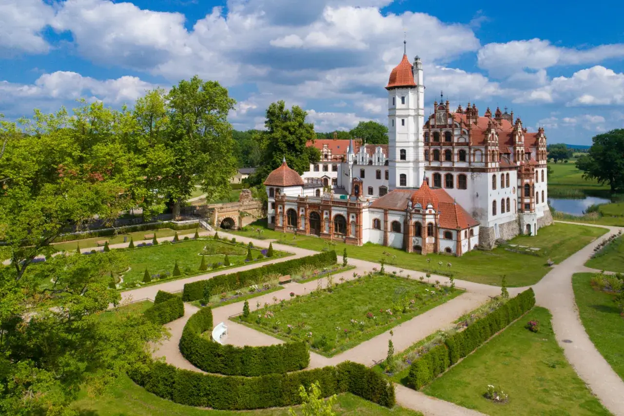 Schloss Basedow, ein historisches Anwesen, das heute als farmer hotel dient, mit gepflegten Gärten und einem malerischen Teich.