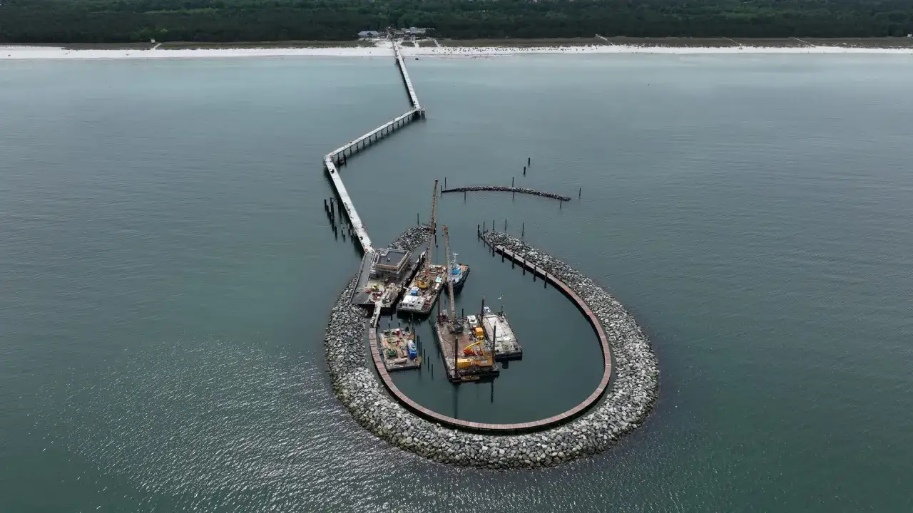 Der Prerow Hafen mit seiner markanten, hufeisenf&ouml;rmigen Mole, auf der Boote und Kr&auml;ne liegen.