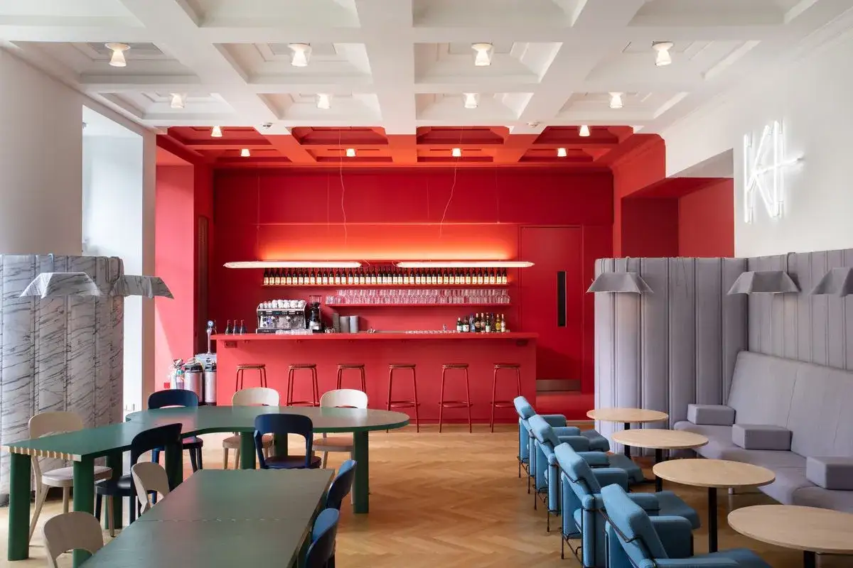 Moderne Bar mit rotem Tresen, Kunstmeile Binz. Sitzbänke und blaue Sessel laden zum Verweilen ein.