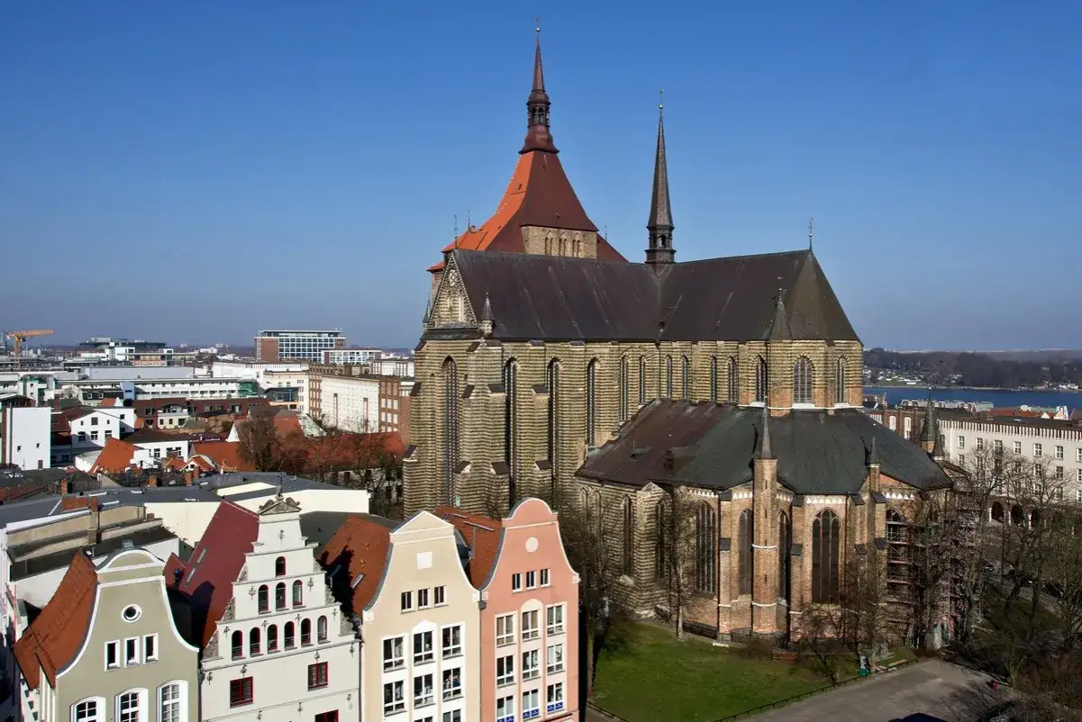 Blick über die Dächer der Rostock Innenstadt mit der Marienkirche und bunten Giebelhäusern.
