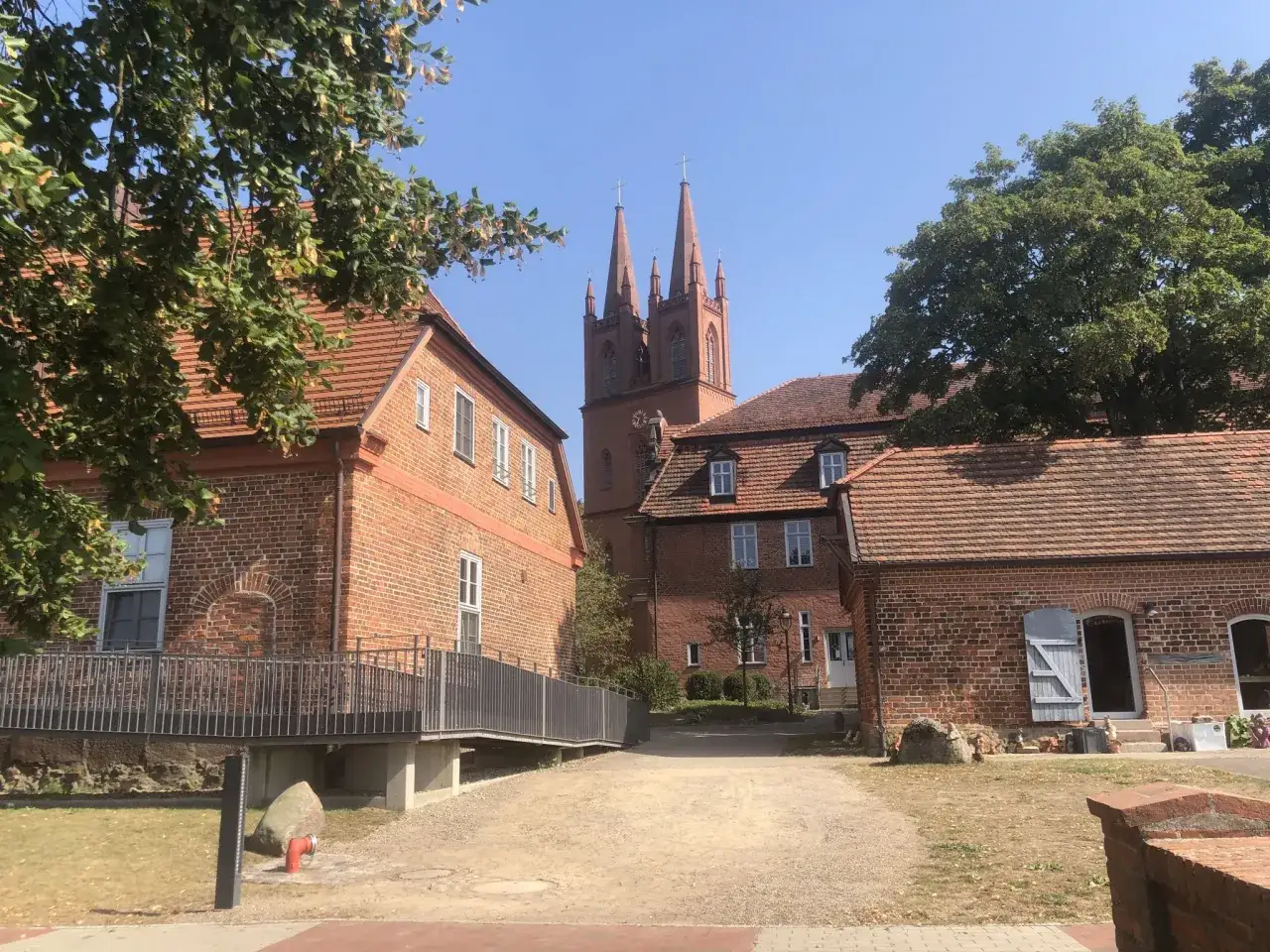 Zwei Kircht&uuml;rme ragen &uuml;ber die roten Ziegeld&auml;cher des Klosters Dobbertin.